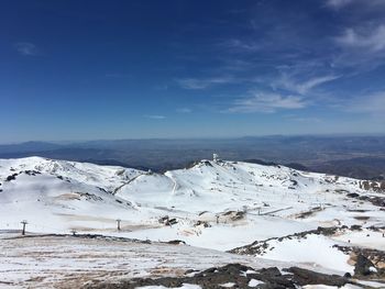 Scenic view of snowcapped mountains against blue sky