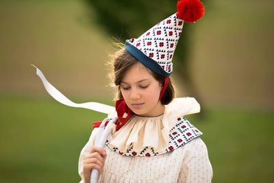 Girl in costume looking down while standing outdoors