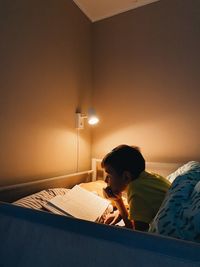 Portrait of young woman sitting on bed at home