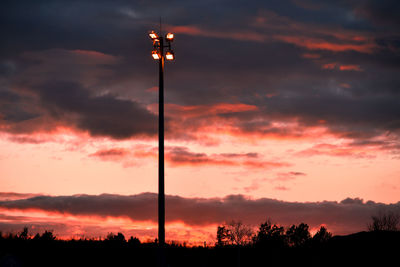 Low angle view of silhouette trees against orange sky