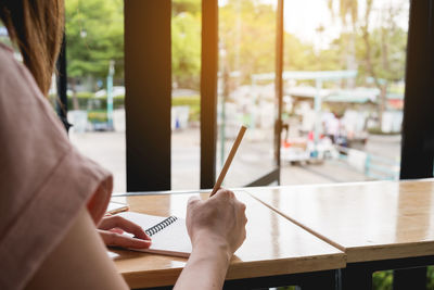 Midsection of woman holding umbrella on table