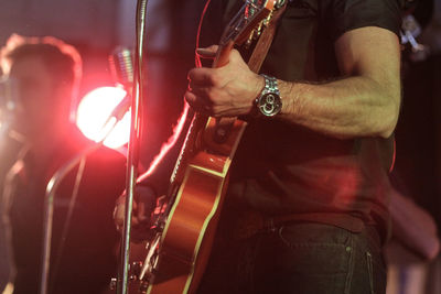 Midsection of man standing at music concert