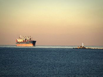 Boats in sea at sunset