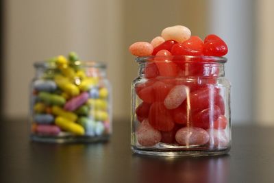 Close-up of multi colored candies in jar on table
