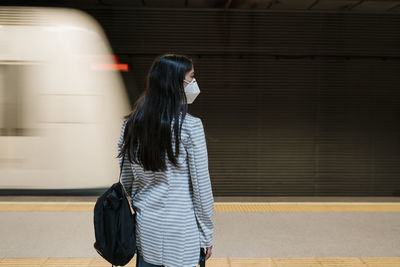 Woman standing at railroad station