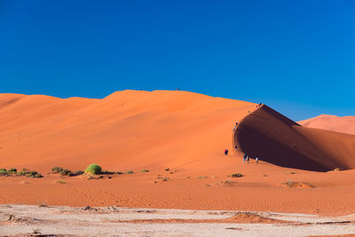 Scenic view of desert against clear blue sky