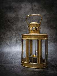 Close-up of electric lamp on table against wall