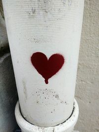 Close-up of heart shape made on white wall