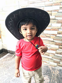 Portrait of cute boy wearing hat while standing outdoors