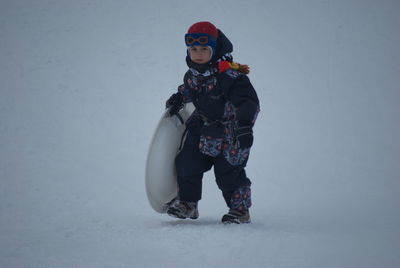 Portrait of man standing on snow covered field