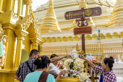 Group of people outside temple against building