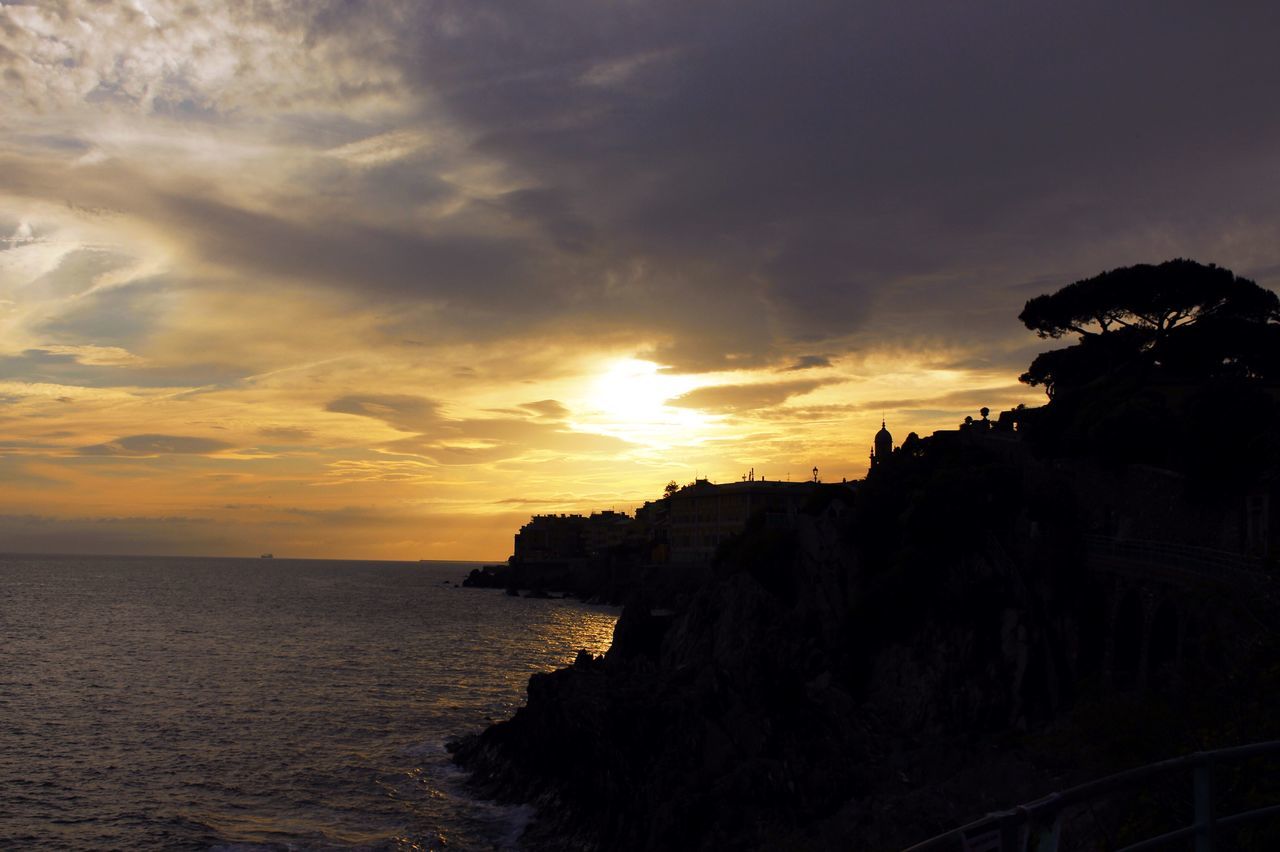 sea, sunset, horizon over water, water, sky, scenics, beauty in nature, tranquil scene, tranquility, cloud - sky, silhouette, nature, idyllic, cloud, beach, rock - object, building exterior, built structure, cliff, orange color