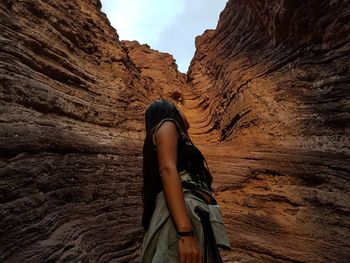 Low angle view of woman standing by cliff