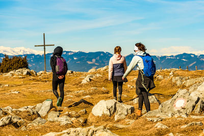 Rear view of people on rock against sky