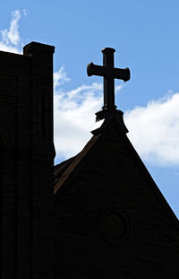 Low angle view of cross on building against sky