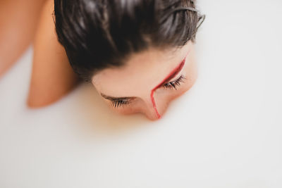 Close-up of thoughtful young woman taking milk bath