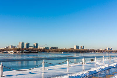 River by city against clear blue sky