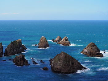 Scenic view of rocks in sea against sky