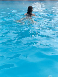 Rear view of woman swimming in pool