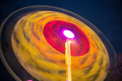 Close-up of illuminated carousel against sky at night