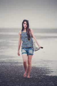 Portrait of young woman standing on beach