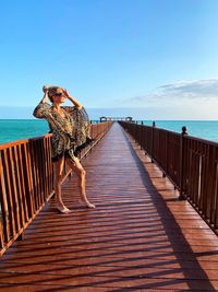 Woman looking away while standing on pier