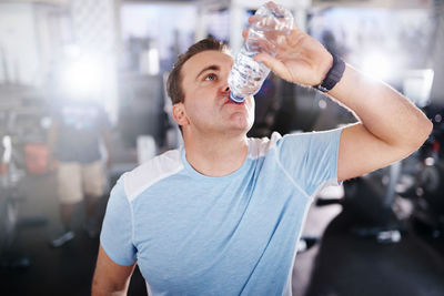 Man drinking water at gym