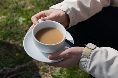 Midsection of man holding tea cup