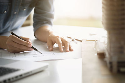 Midsection of man working on table