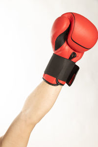 Close-up of hand holding eyeglasses against white background