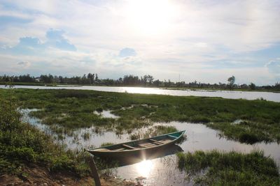 Boat moored in lake against sky