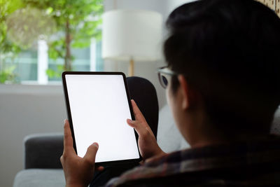 Rear view of man using mobile phone