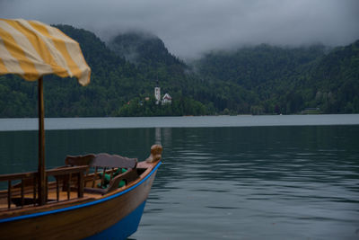 Boat moored on lake against sky