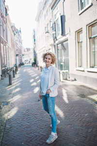 Portrait of happy mid adult woman walking on street in city