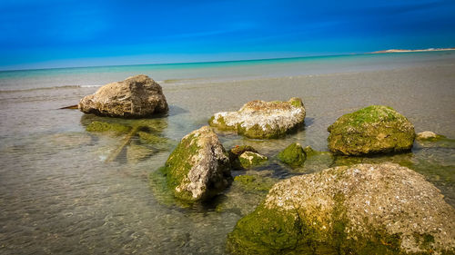 Rocks on beach against sky