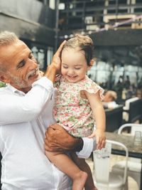 Mature man holding baby girl