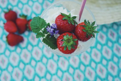 High angle view of strawberries in ice cream on table