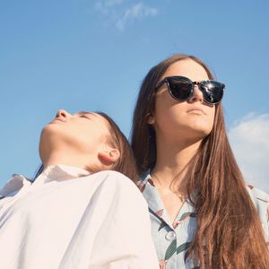 Portrait of woman with sunglasses against sky