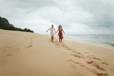 Women standing on beach against sky