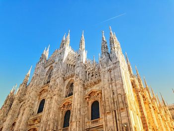 Low angle view of milan cathedral against blue sky