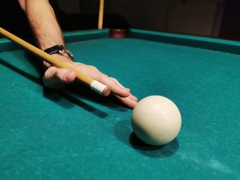 Person playing with ball on table, snooker game