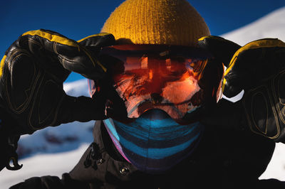 Skier in ski goggles with reflection of snow-capped mountains in them. portrait of a man in a ski