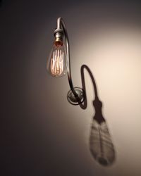 Low angle view of illuminated sconce light on wall