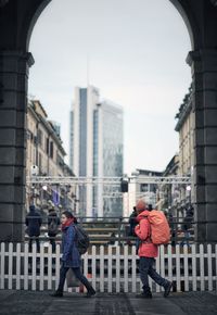 Rear view of people walking on buildings in city