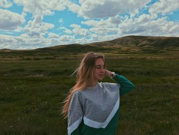 Woman standing on grass against sky