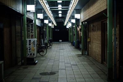 Empty alley amidst buildings at night