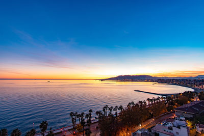 High angle view of people on beach against sky during sunset