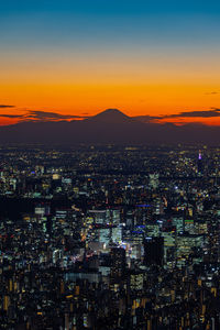 High angle view of illuminated cityscape against sky at night