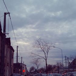 Cars on road against cloudy sky