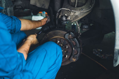 Midsection of man repairing car